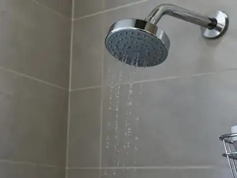 Shower head releasing a weak trickle of water from low well pressure